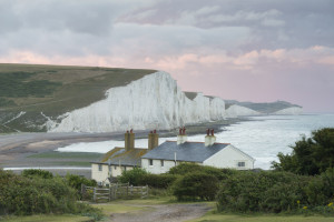 Stormy skies over the coastgard cottages at Cuckmere Valley, East Sussex, with the Seven Sisters seen beyond.